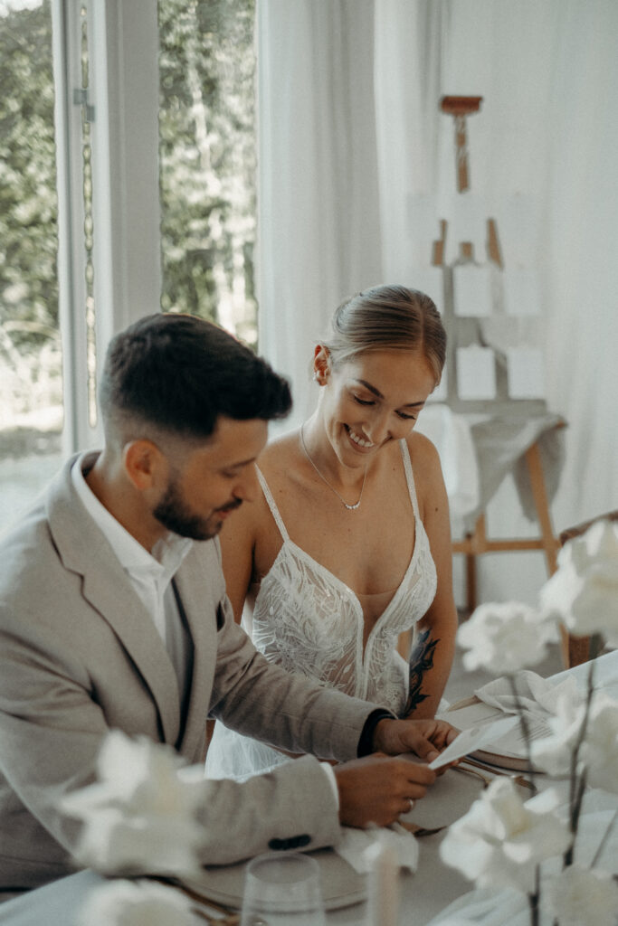 Ästhetisches Brautpaar hält Menükarte am Hochzeitstisch