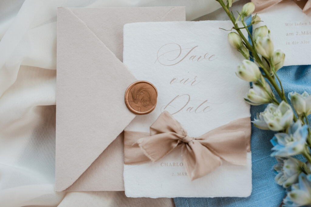 Elegante Hochzeitsankündigung auf Büttenpapier mit Seidenband in beige